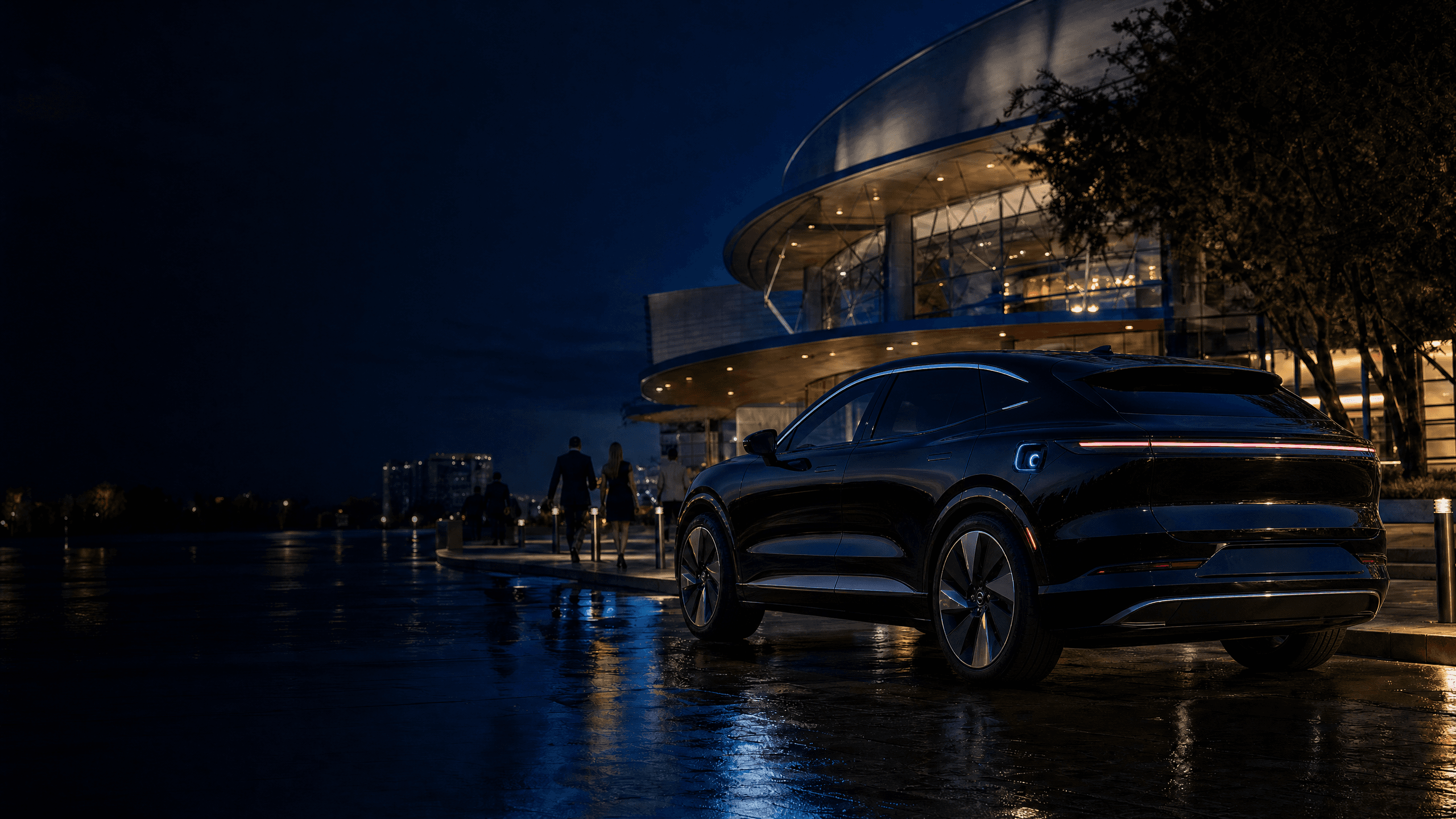 Black electric vehicle outside a softly lit entertainment district at night